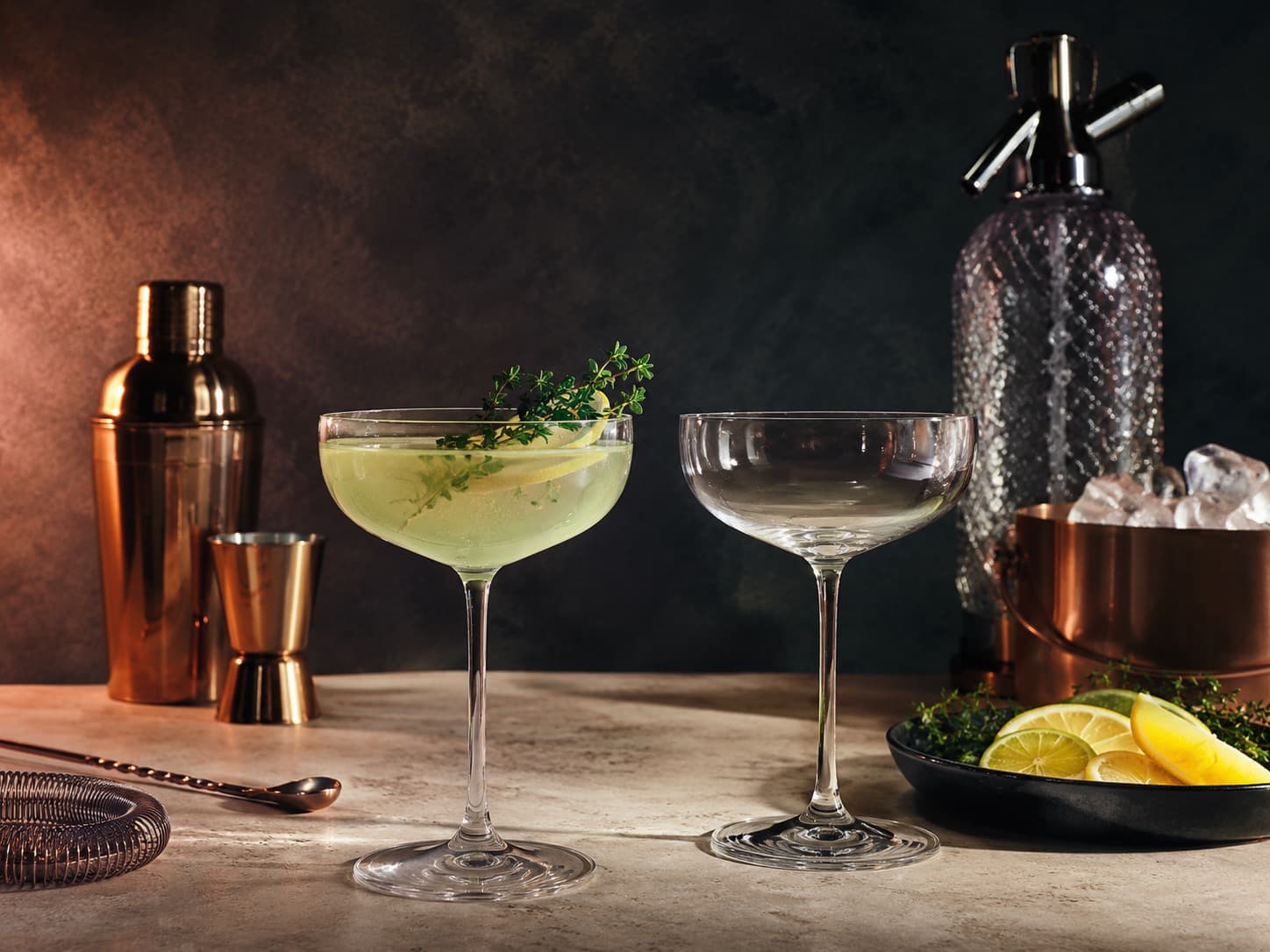 Coupe Glass Pair arranged on a dark stone surface