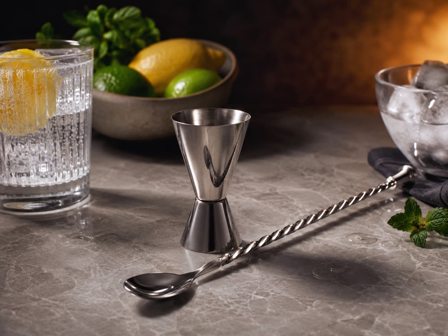 Japanese Jigger & Bar Spoon Duo arranged on a dark stone surface